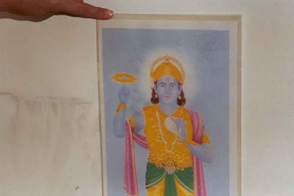 Soot like stains on the picture of Lord Krushna and the wall